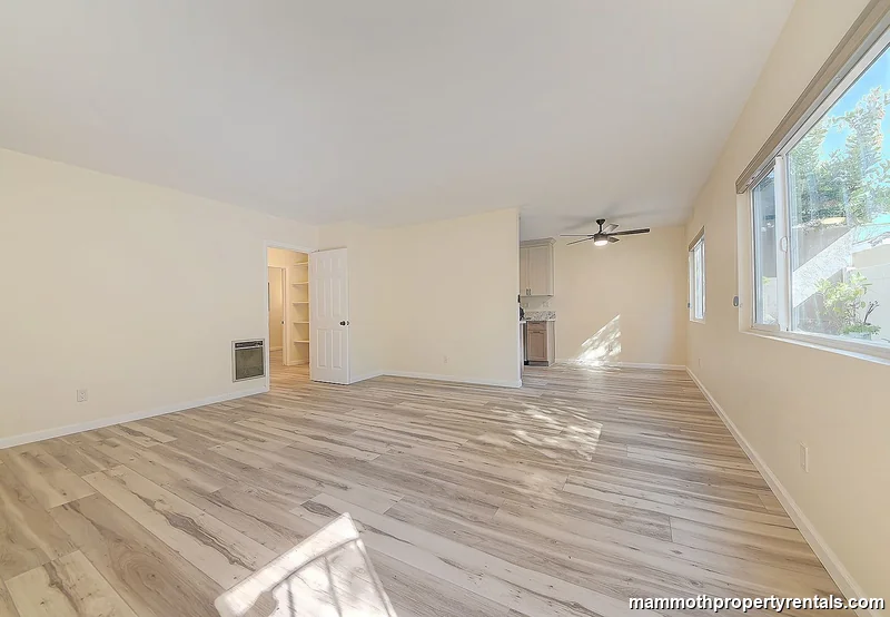 Bright, open living and dining area with high ceilings and wide-plank flooring - perfect for relaxing or working from home.