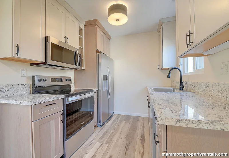 Kitchen showing the sink, window, and generous cabinet space.
