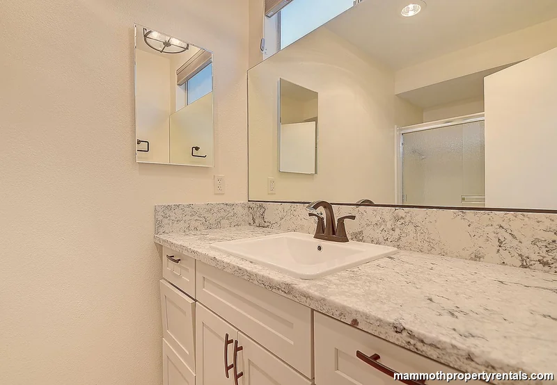 Master bathroom - wide vanity with lighted mirror and generous counter space.