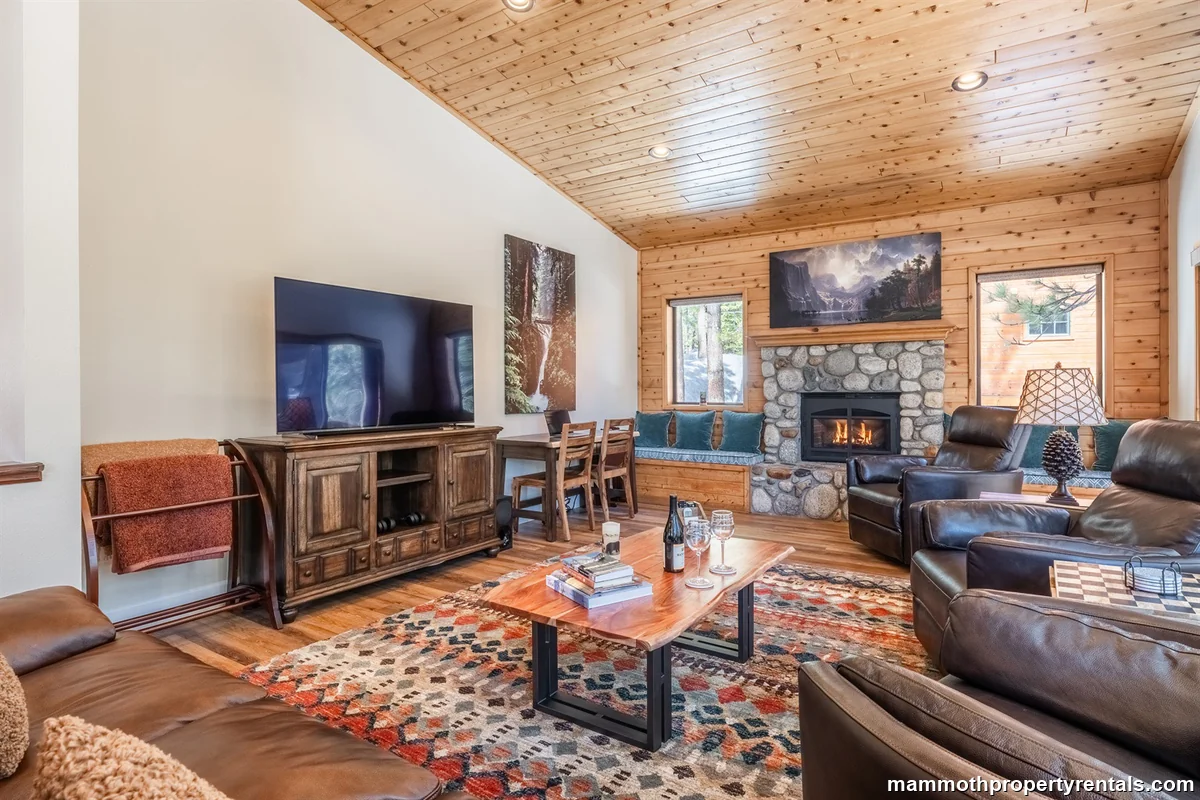 Cozy living room with fireplace, ample seating and beautiful mountain views through the windows. A great place to relax after a day of winter activities!