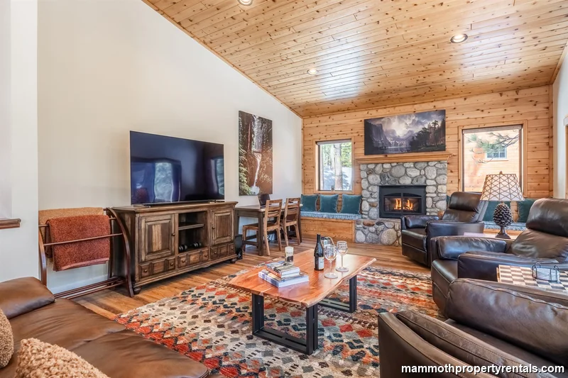 Cozy living room with fireplace, ample seating and beautiful mountain views through the windows. A great place to relax after a day of winter activities!